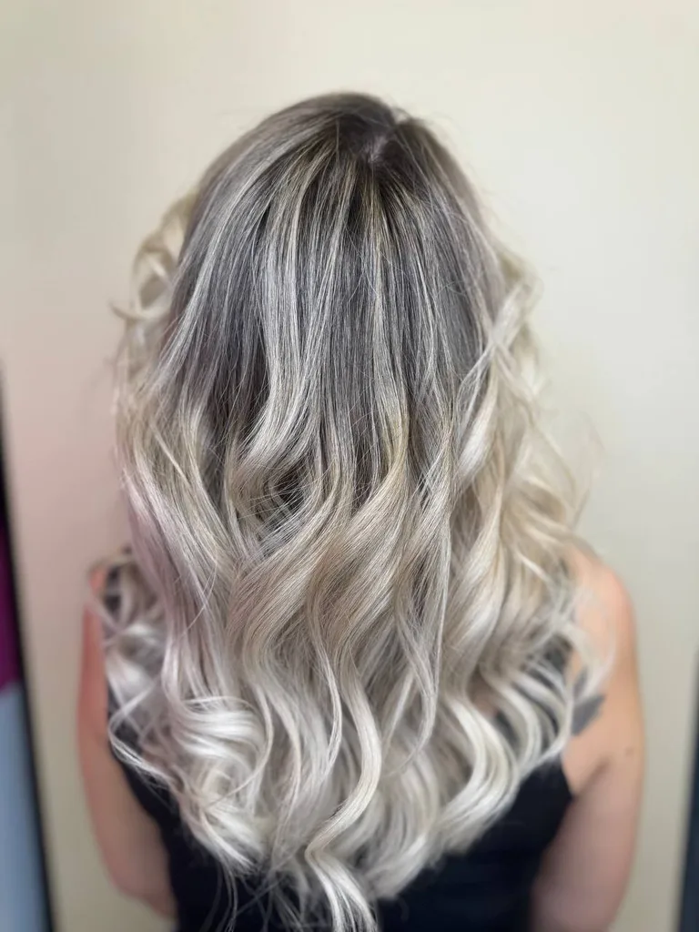 Păr lung cu rădăcină închisă și lungimi blond perlat, cu bucle