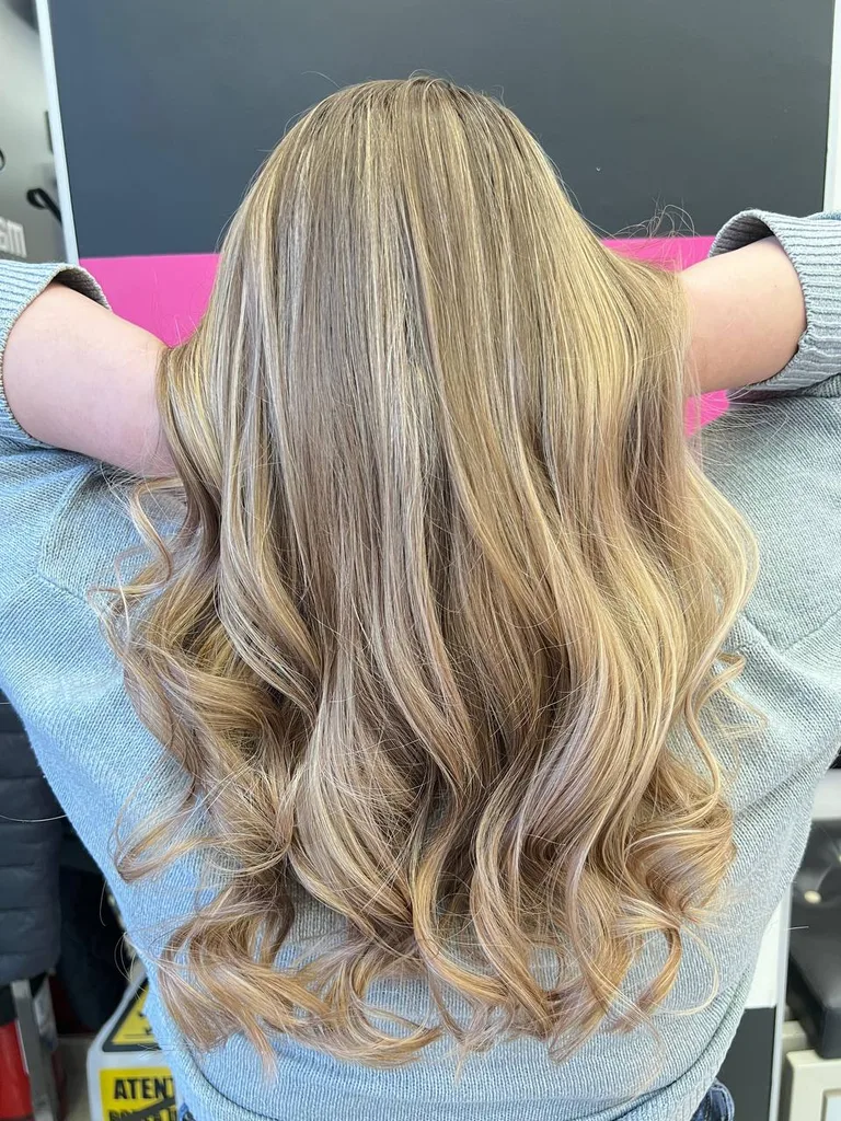 Balayage blond miere pe păr lung și ondulat