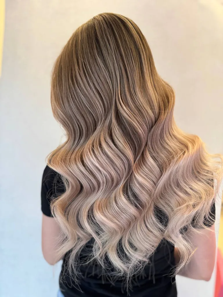 Ombré de la șaten la blond rozaliu pe păr lung și ondulat