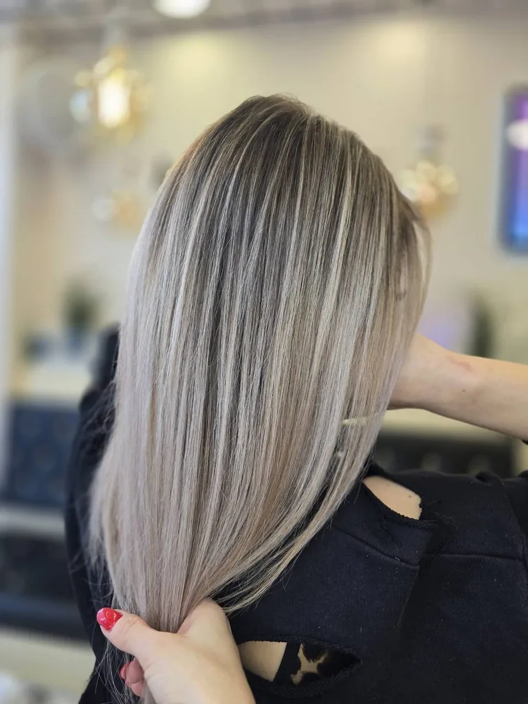 Șuvițe blond cenușiu pe păr drept, lungime medie, din profil